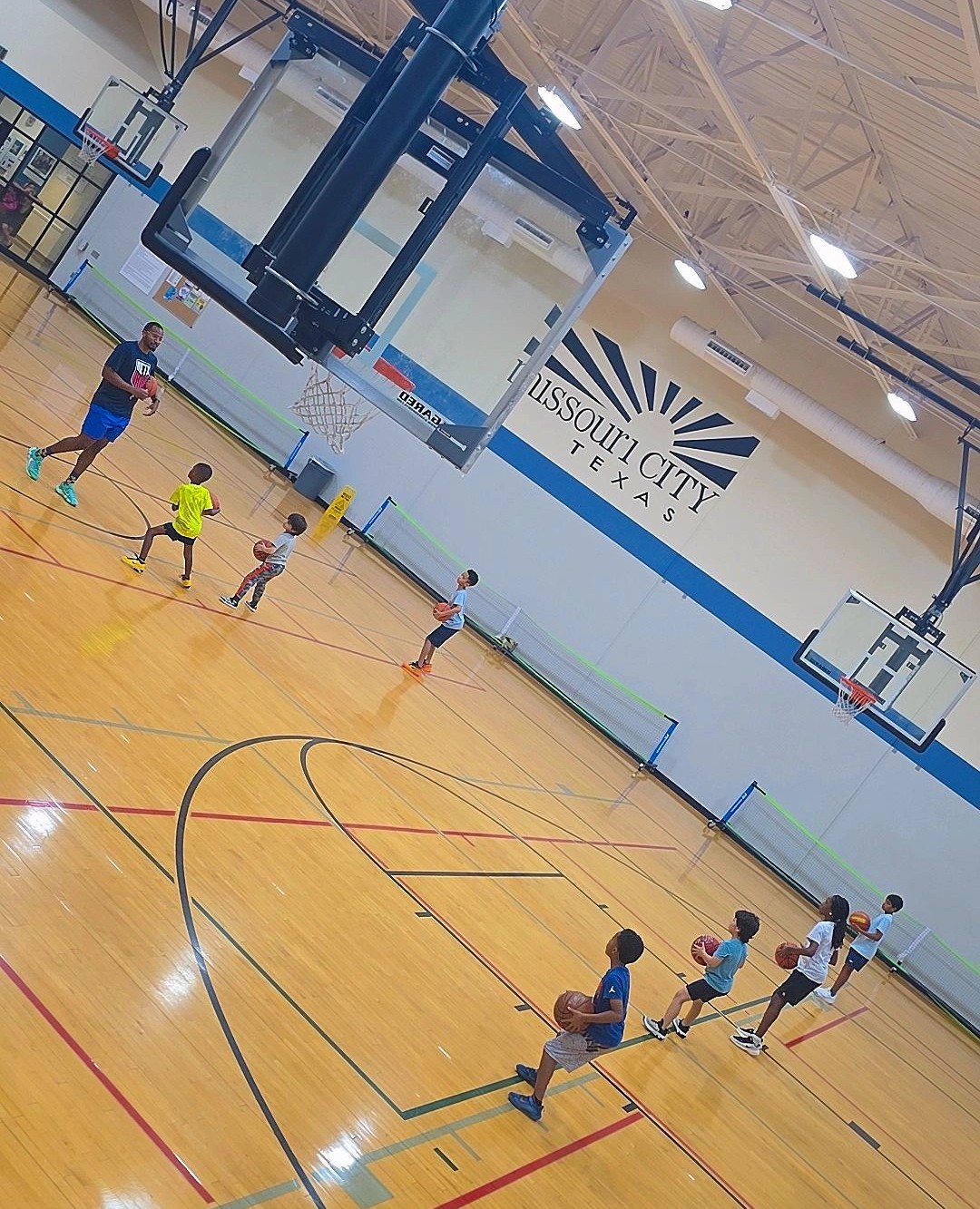 Young athlete driving to the basket under dramatic teal and orange court lighting